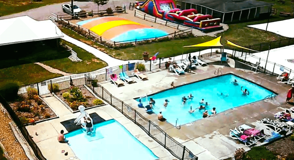 Pool area with splash pad and bounce houses
